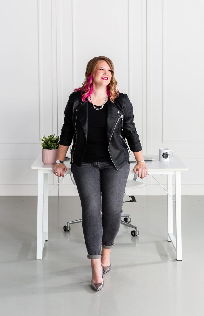 Pamela smiling confidently in a modern workspace, representing efficient VIP Day solutions for women entrepreneurs.