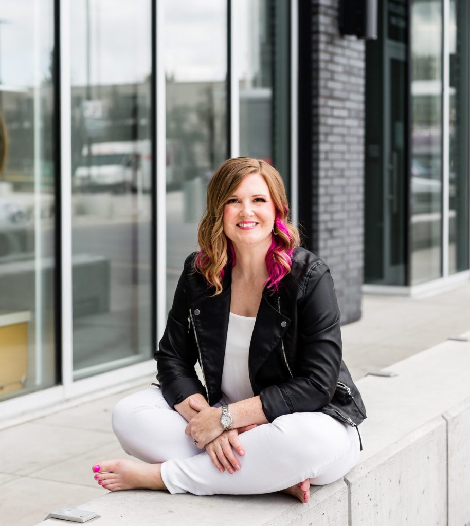 Pamela, tech VA and systems strategist, sitting casually outside an office building