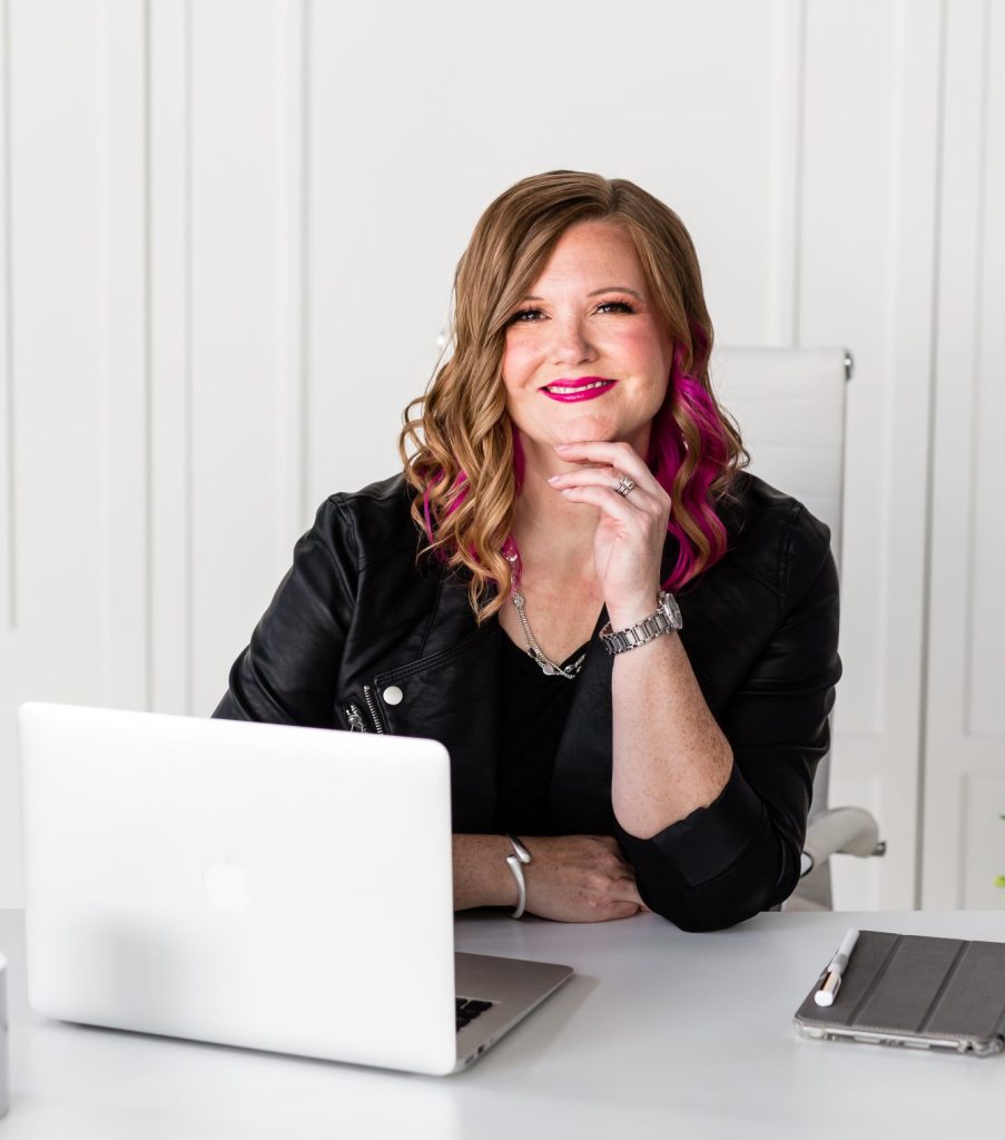 Pamela, a Canadian tech VA and systems strategist, smiling at her desk during a virtual client consultation.
